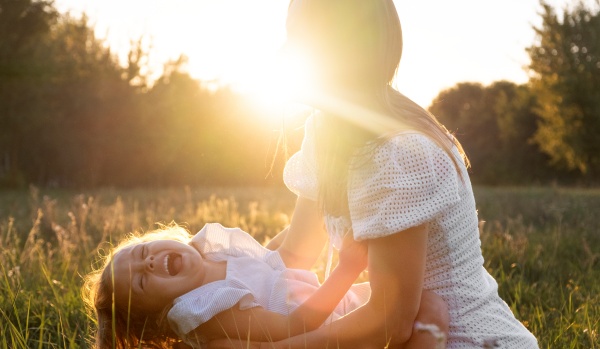 Frau und Kind spielen in der Sonne und nehmen damit Vitamin D3 auf